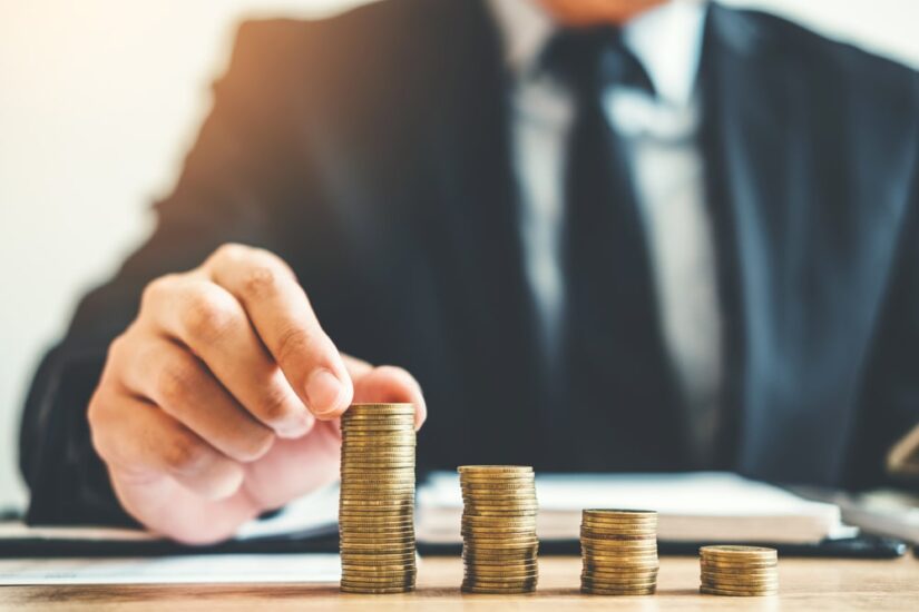 Man Stacking Coins In Front Of Him